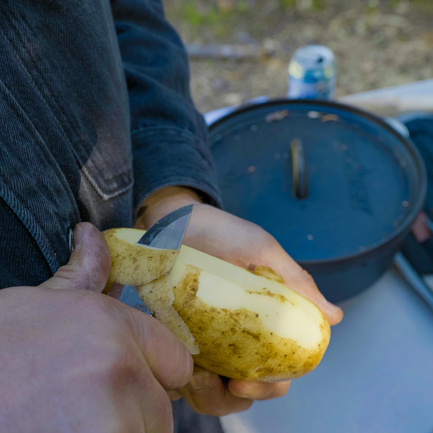 Knafs Lulu fixed blade knife peeling potatoes on an outdoor cutting board